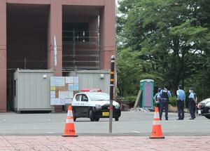 弥彦総合文化会館の爆発事故から一夜明け、現場を警戒する警官=6月30日午前9時ごろ、弥彦村弥彦