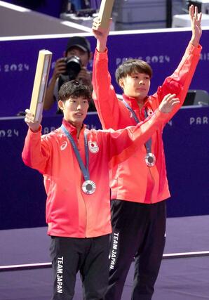 フェンシング　男子エペ団体銀メダルを獲得し、メダルセレモニーの後、スタンドに手を振る古俣聖（左）＝８月２日、パリ（新潟日報社写真映像部・新井田悠）