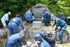 慰霊碑の周辺を清掃する小出署と消防本部の職員ら=10日、魚沼市大白川