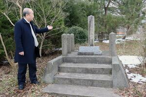 神社跡に残された石碑を紹介する富山修一社長=新潟市北区太夫浜