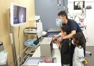 興味津々で胃の内視鏡検査を体験する参加者=7月27日、長岡市旭岡1
