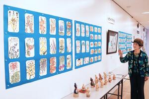 花や野菜を色鮮やかに描いた作品が並ぶひまわり絵手紙展=アオーレ長岡