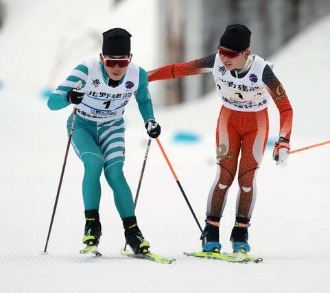 男子４×５キロリレー　３走の田中瑛翔（黄・右）がアンカーの我田平（青）へリレー＝６日、長野県の野沢温泉南原クロスカントリーコース（写真映像部・伊藤駿平）