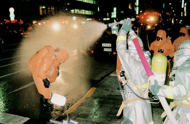 小伝馬町駅前で除染される、東京消防庁の消防隊員（左）＝１９９５年３月２０日、東京都中央区