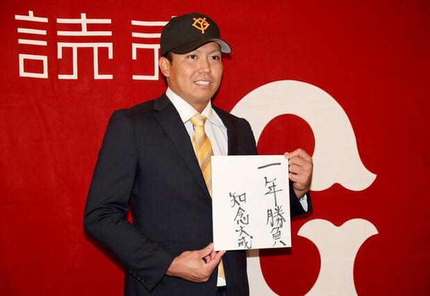 巨人と仮契約を結んだ知念大成。抱負を記した色紙を手に撮影に応じる=新潟市中央区