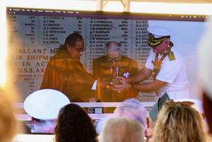 中継会場で参加者が見守る中、真珠湾に献酒する静岡の医師菅野寛也さん(中央)ら=8日、米ハワイの真珠湾(共同)