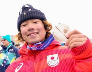 ミラノ・コルティナ冬季五輪のスノーボード男子スロープスタイルで銀メダルを獲得し、笑顔を見せる長谷川帝勝=18日、イタリア・リビーニョ(共同)