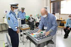 反射神経を測定する安全運転講習の参加者=小千谷市千谷