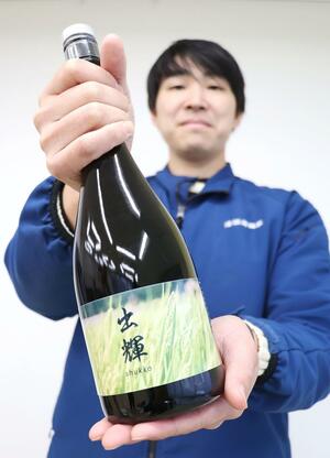 出雲崎町のブランド米を使って誕生した日本酒「出輝」をＰＲする坂東拓哉さん＝出雲崎町尼瀬