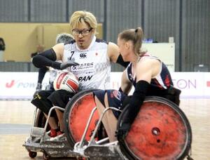 車いすラグビーのジャパンパラ大会の米国戦で攻め上がる池崎(左)=千葉ポートアリーナ