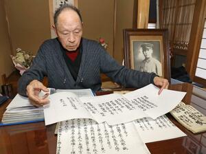 日連丸に乗船し犠牲になった父の富作さんの遺影を前に語る栗山誠さん。父の戦死の知らせや香典の記録は今も大切に保管している＝三条市