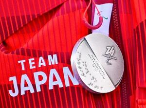 点字が刻まれたミラノ・コルティナ冬季パラリンピックのメダル=13日、イタリア・コルティナダンペッツォ(共同)