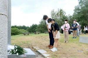 空襲の犠牲者を悼み、記念碑に献花する市民ら=10日、新潟市中央区