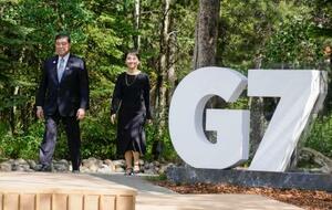 G7サミット会場のカナダ西部カナナスキスで、歓迎セレモニーに向かう石破首相。右は妻の佳子さん=16日(共同)