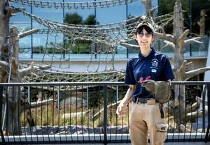 「フリーフライト」の事故があったサル山前で革手袋を着け、猛禽類を手に乗せるポーズで立つ菊池晏那。つらい経験だったが今は前を向き飛行再開に備える=2025年7月、札幌市の円山動物園(撮影・今里彰利)
