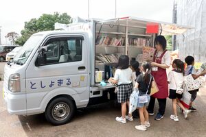 新しい移動図書館車に集まり本を選ぶ児童ら=聖籠町蓮野