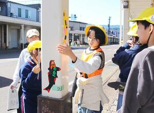 商店街のアーケードに錦鯉のマグネットシートを貼る児童ら=小千谷市東栄1