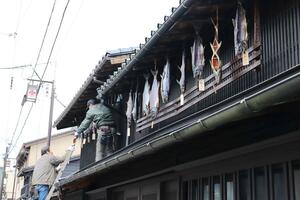 民家や商店の軒下に塩引き鮭が並ぶ「越後村上鮭塩引き街道」の準備作業=村上市小町