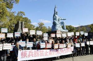 核兵器禁止条約の発効から５年となるのを前に開かれた集会でプラカードを掲げる参加者＝１月２１日午前、長崎市の平和公園