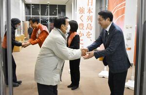 自民党の候補者と並んで市民と握手を交わす中原八一新潟市長＝３日、新潟市西区