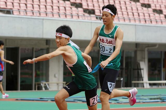 男子 中越の2区村田大翔(右)が3区丸山展にタスキリレー=新潟市中央区