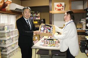 県フードバンク推進協に食品セットを寄贈したＮＴＴ東日本新潟支店の石井宏明支店長（左）＝４日、三条市北新保１
