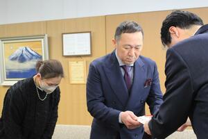 鈴木力市長(右)に寄付金を手渡す徐直幸さん(中央)、妻の歌織さん=、燕市吉田西太田