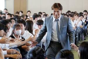 特別授業のため訪れた中学校で、生徒たちとタッチを交わす柔道男子の阿部一二三=30日、大阪府高槻市