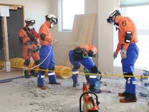 コンクリートの床に穴を開けて下の階に降り、救助に当たる訓練をした上越地域消防局の特別救助隊員=10月7日、妙高市中町の旧妙高市いきいきプラザ