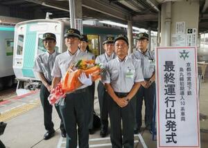 京都市営地下鉄烏丸線の竹田駅で行われた初期車両の引退セレモニー。手前左は花束を手にする長尾耕太郎さん=8日午後