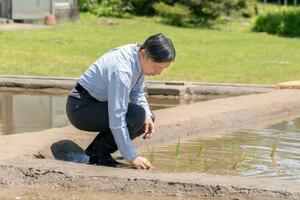 皇居内の水田で田植えをされる天皇陛下=13日午前(宮内庁提供)