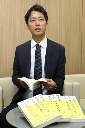書籍を紹介する山﨑寛己さん=新潟市中央区