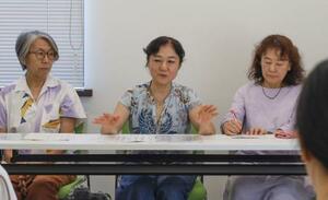 京都市役所で記者会見する画家・版画家の田中直子さん(中央)ら=30日午後