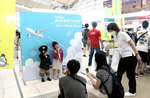パイロットやキャビンアテンダントの制服を着て記念撮影する子どもたち=7月27日、新潟市東区松浜町
