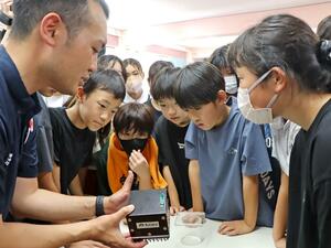 国際宇宙ステーションで種もみを保管する箱を見る児童たち=上越市東本町2