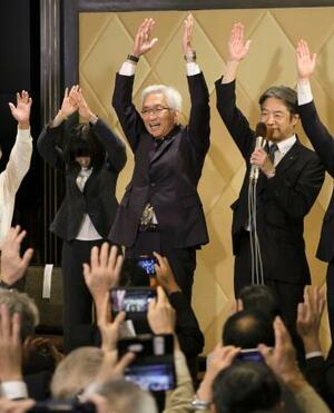 京都選挙区で当選を決め、万歳する自民党の西田昌司氏(中央)=20日深夜、京都市内のホテル