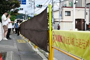 コンビニ越しの富士山を撮影できるスポットに1年ぶりに設置された幕=14日午後、山梨県富士河口湖町