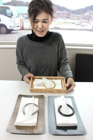 阿部工業が開発販売したティッシュディスペンサー。企画した山本恵美子さんは「旅館やホテルの部屋にもマッチする」と話す=三条市下保内