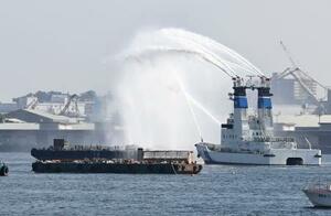 台船へ放水する消防船=5日午前、横浜市