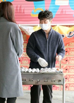 さまざまな品種のサツマイモを焼く野澤健太さん＝新潟市中央区の白山市場