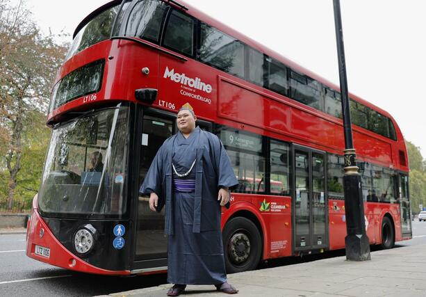 ロンドン名物の２階建てバスと写真に納まる横綱大の里＝１２日（共同）