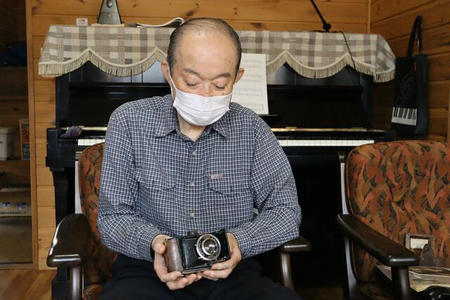 父が愛用していたカメラを手にする高野荘平さん=長岡市