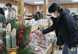 正月飾りや地元の野菜などが並び、買い物客でにぎわった年越しまつり＝２８日、妙高市猪野山