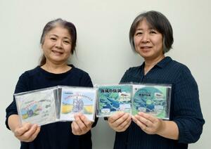 旧頸城鉄道の物語や頸城区の伝説をまとめたDVDを手にする、大越さとみさん(左)と小山あゆみさん