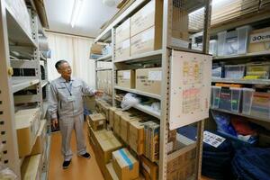 避難所となった青森県八戸市の小中野公民館で、災害時の備品に関して説明する上條秀信館長=10日午後