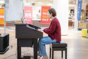 佐渡セントラルタウンでリクエスト曲を「耳コピ」で弾く知本未歩さん=佐渡市窪田(本人提供)