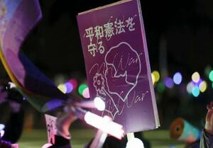 国会前で掲げられた「平和憲法を守る」と記されたプラカード＝４月８日