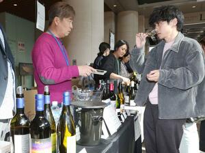 県内１０ワイナリーのボトルが並び、来場者が試飲などを楽しんだイベント＝８日、新潟市中央区万代３