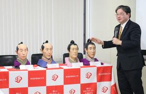 復元された長岡藩牧野家の8代藩主・忠寛(右)や5代藩主・忠周(左隣)の顔の模型などを前に遺伝子解析の結果を説明する奈良貴史教授=長岡市幸町2