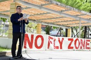 沖縄国際大にヘリが墜落した事故から21年となり、米軍普天間飛行場の早期閉鎖を求める集会で声明文を読み上げる安里肇学長=13日午後、沖縄県宜野湾市